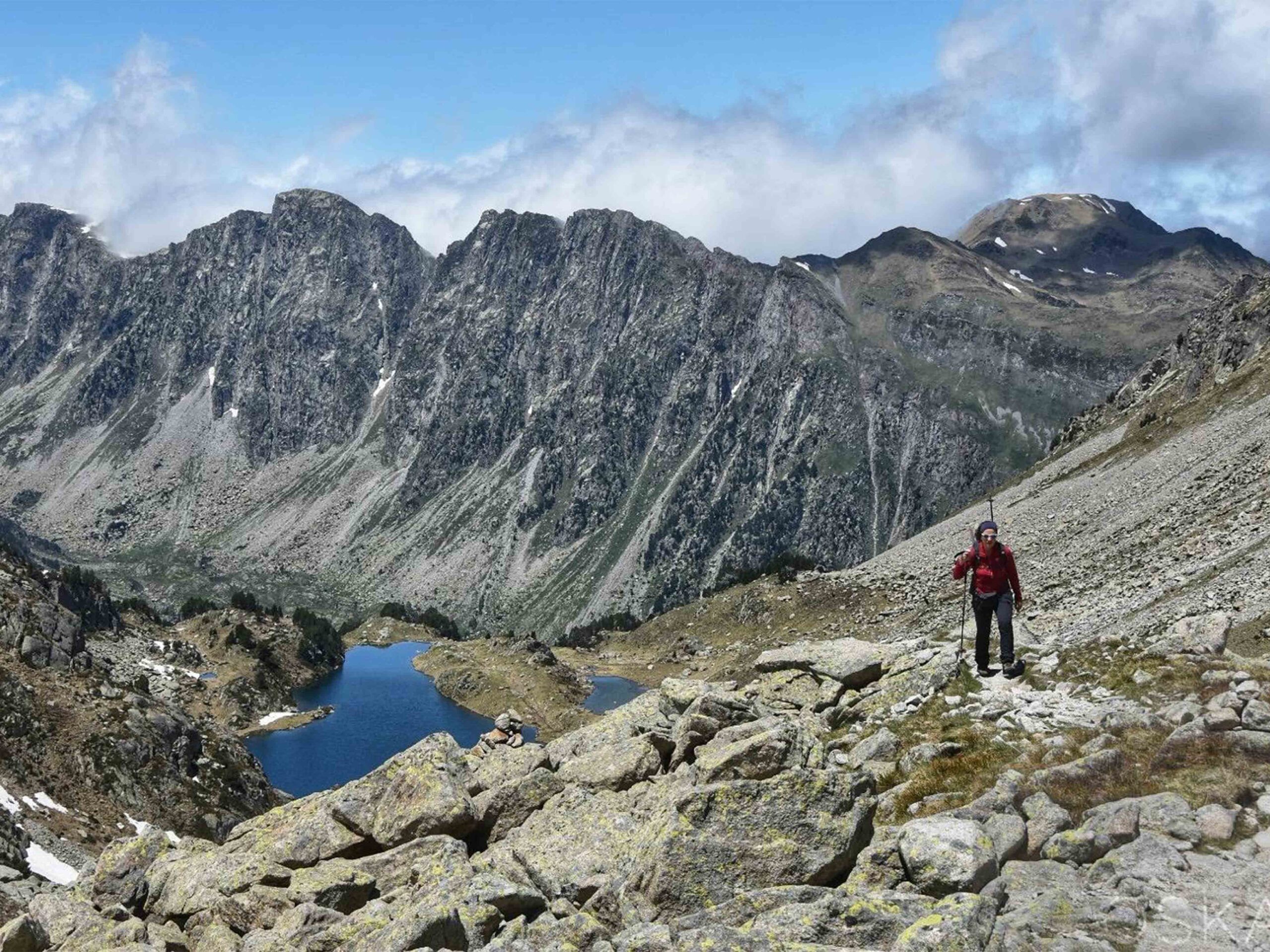 Hikers trekking in the Pyrenees mountains, experiencing nature and learning Spanish through outdoor adventures.